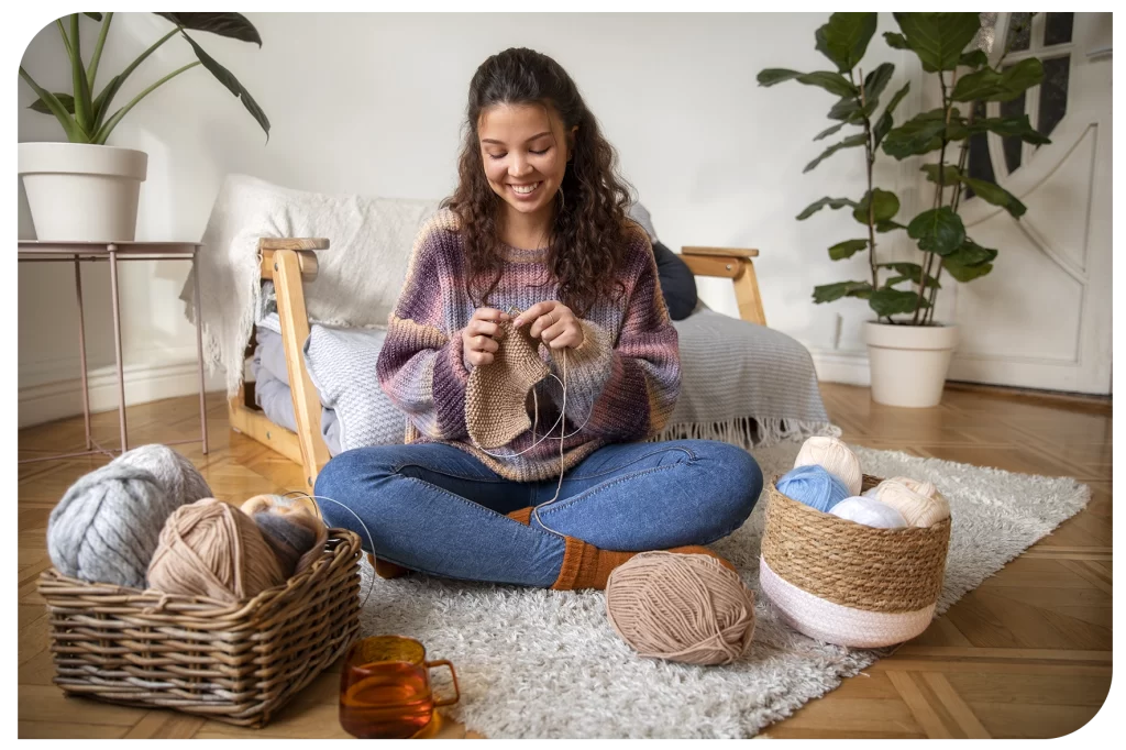 Mulher fazendo crochê na sala de casa.