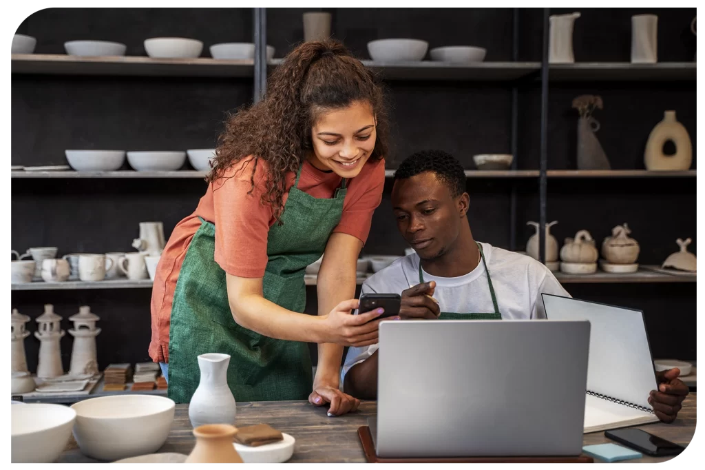 Loja de produtos artesanais com pessoas ao computador.